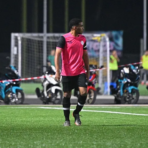 Amin Shennan on the pitch in a pink kit during a night match