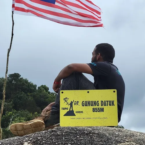 Amin Shennan sitting on the summit of Gunung Datuk