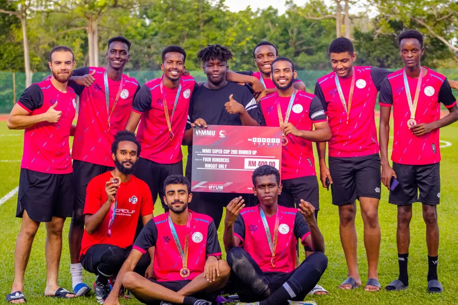 The team in pink kits with medals at the MMU Super Cup